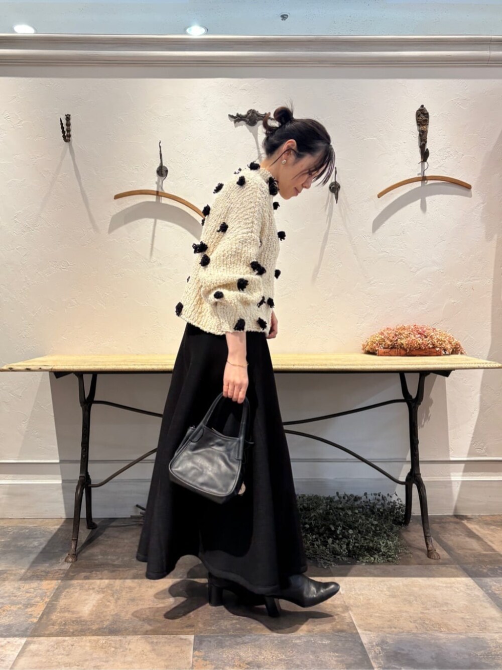 ブラック系のトートバッグ、ブラック系のスカートを着用したレディースの冬コーディネートの2枚目の写真