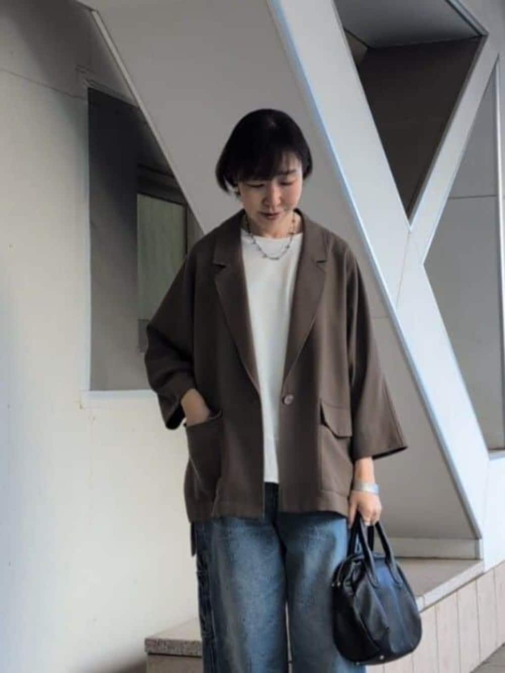 ブルー系のその他パンツ、ブラウン系のテーラードジャケット、ホワイト系のTシャツ/カットソーを着用したレディースの春コーディネートの5枚目の写真