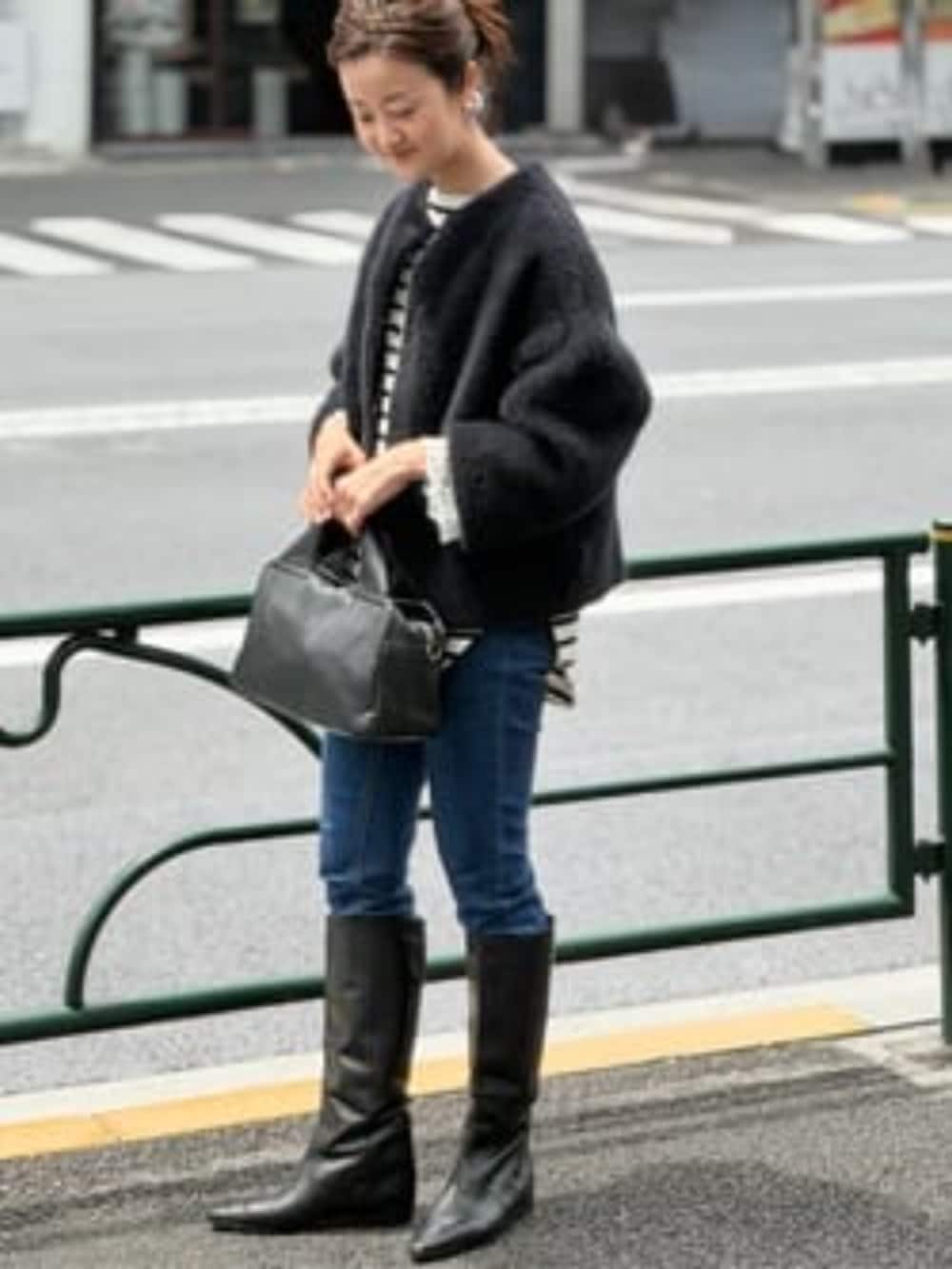 ブルー系のデニムパンツ、ブラック系のその他アウター、ブラック系のボストンバッグを着用したレディースの夏コーディネートの5枚目の写真