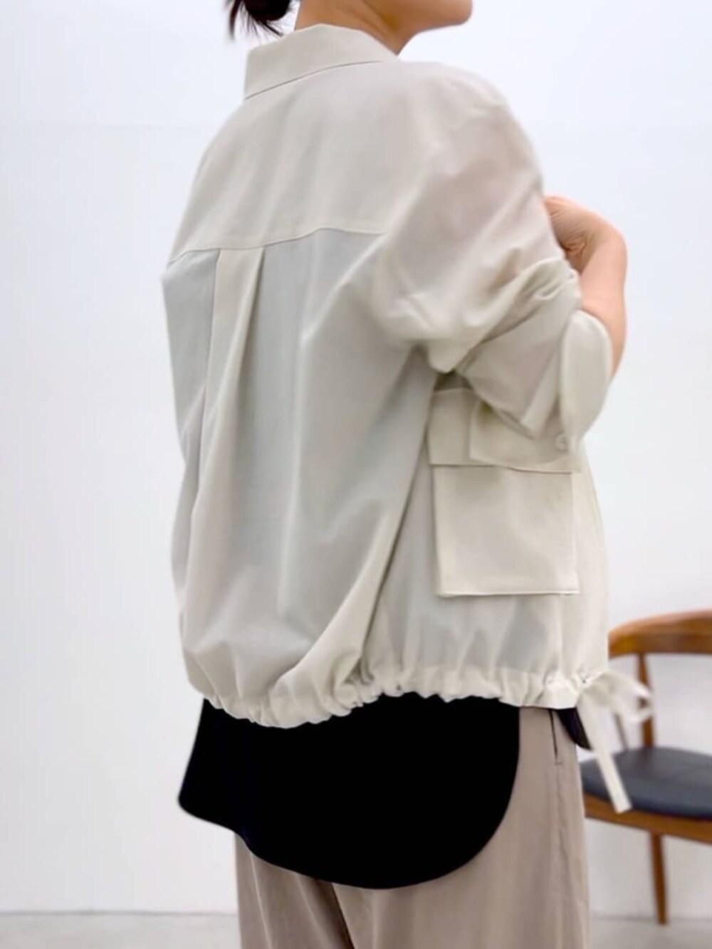 ブラック系のキャミソール、ホワイト系のブルゾン、グレー系のその他パンツを着用したレディースの夏コーディネートの9枚目の写真