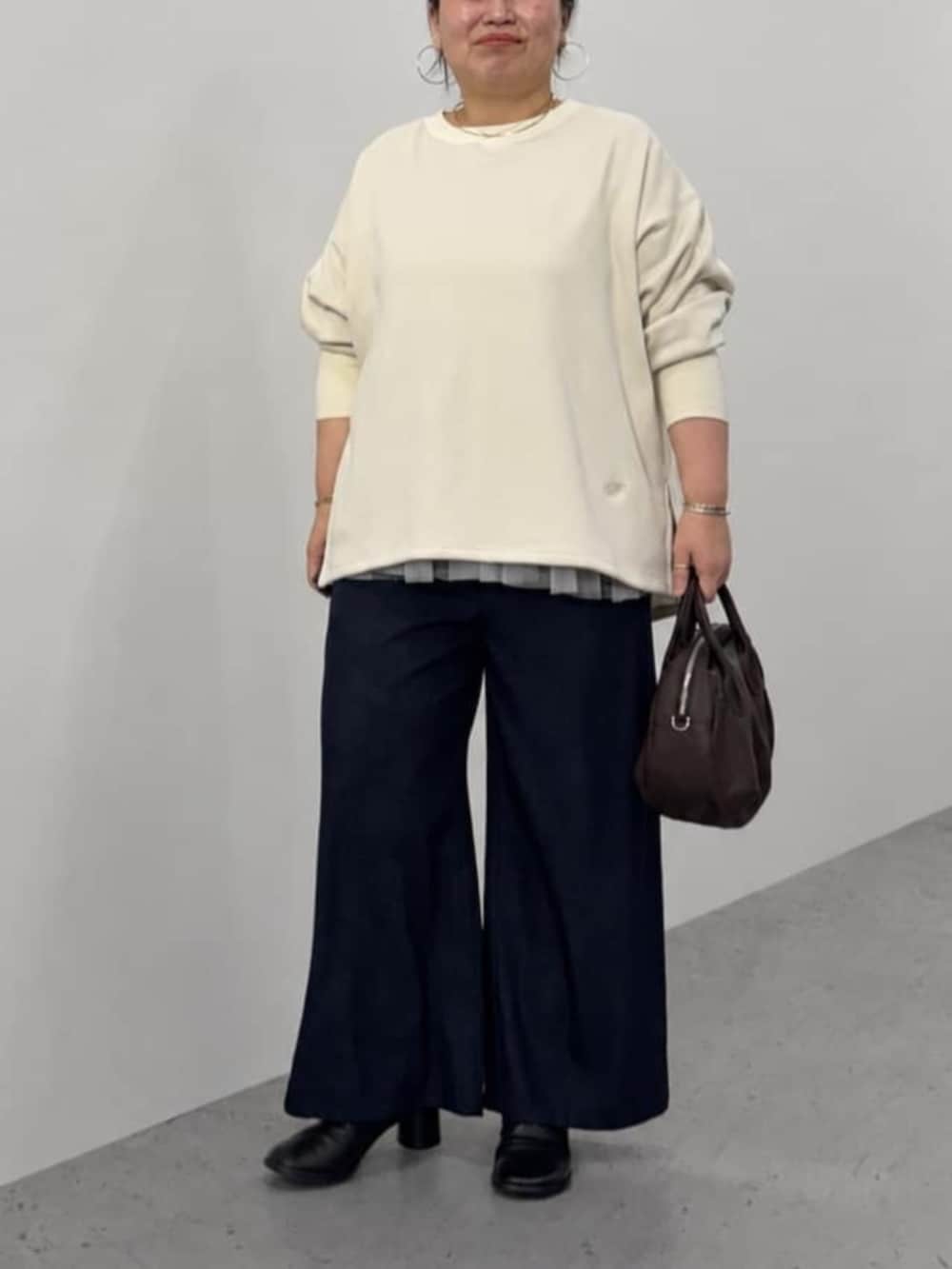 ブルー系のその他パンツ、ブラウン系のトートバッグ、ホワイト系のTシャツ/カットソーを着用したレディースの秋コーディネートの3枚目の写真