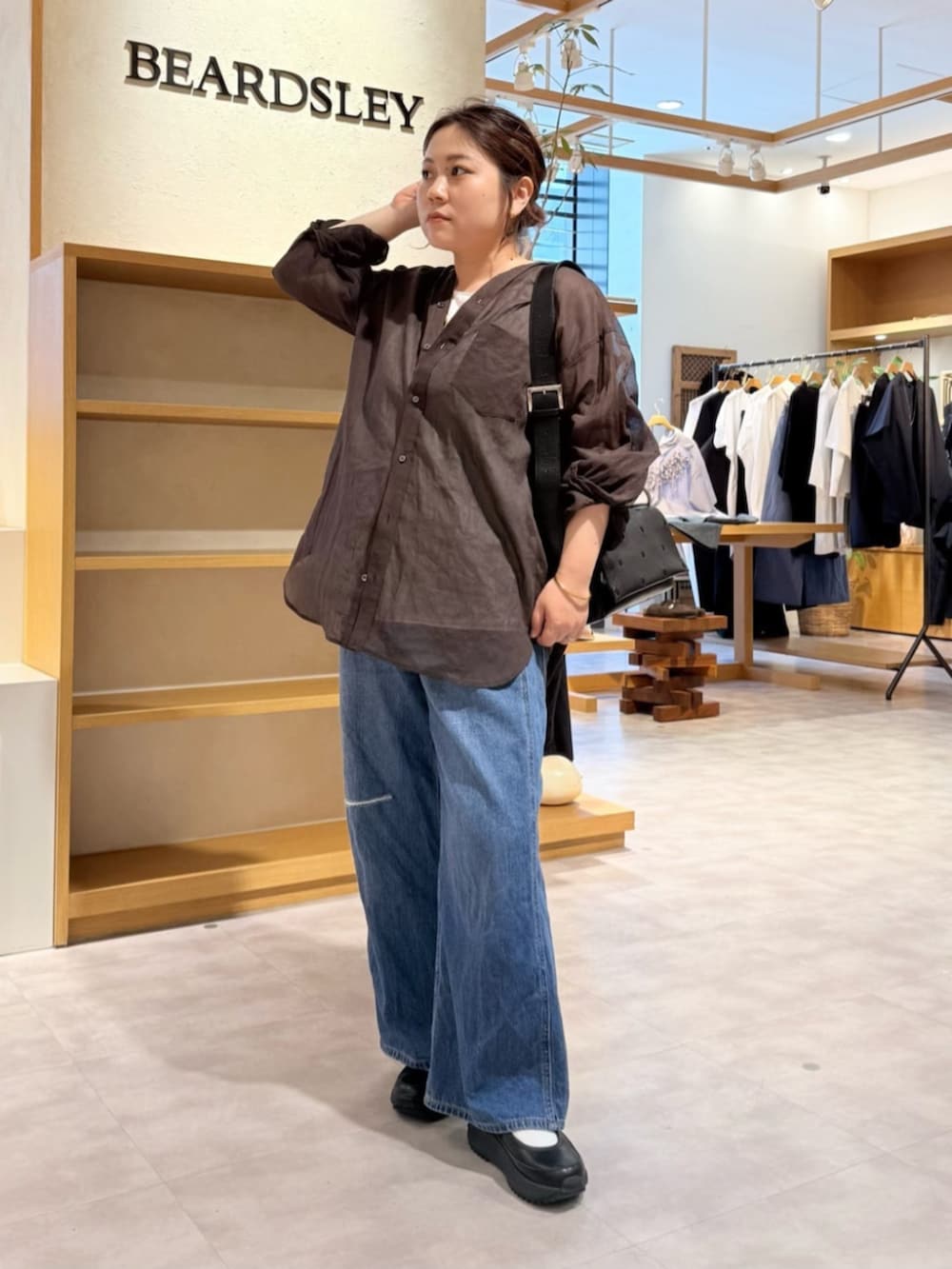 ブルー系のその他パンツ、ブラック系のスニーカー、ブラウン系のシャツ/ブラウスを着用したレディースの春コーディネートの5枚目の写真