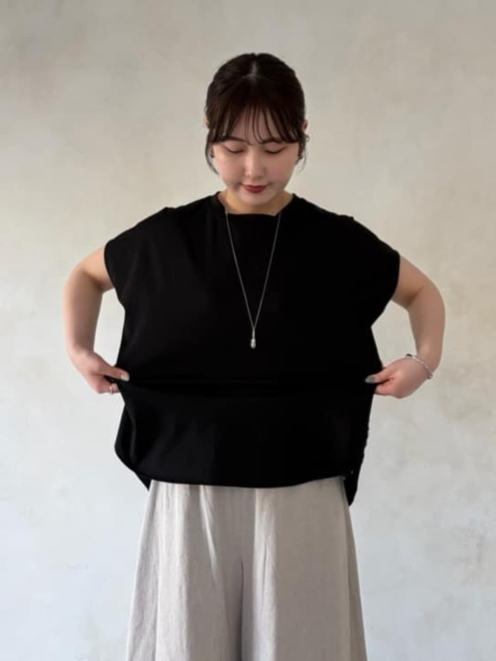 ブラック系のボストンバッグ、ブラック系のサンダル、ベージュ系のその他パンツを着用したレディースの春コーディネートの4枚目の写真