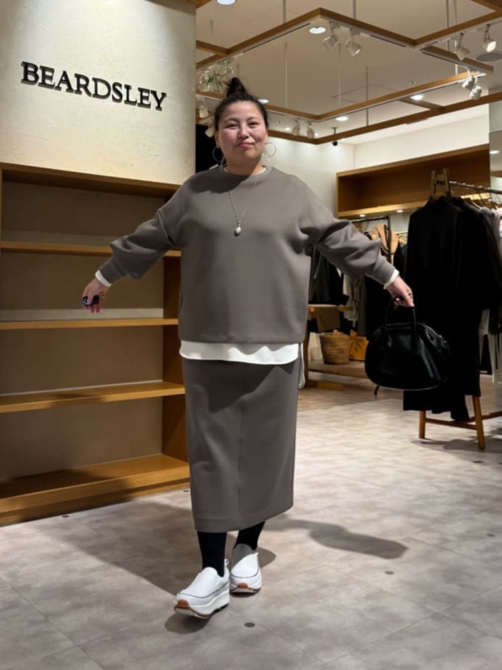 ホワイト系のスニーカー、ブラック系のボストンバッグ、ホワイト系のシャツ/ブラウスを着用したレディースの冬コーディネートの6枚目の写真