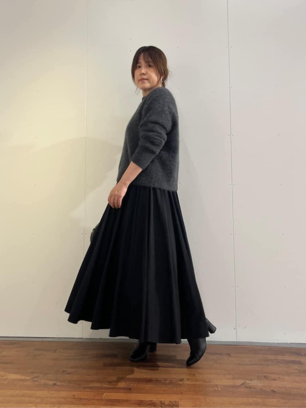 ブラック系のスカート、グレー系のニット/セーターを着用したレディースの秋コーディネートの6枚目の写真