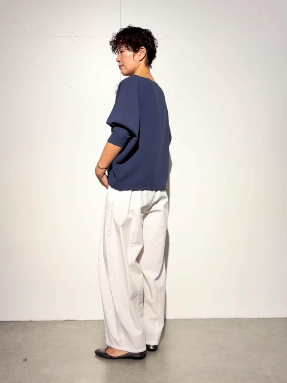 ブラック系のハンドバッグ、ブルー系のシャツ/ブラウス、ホワイト系のその他パンツを着用したレディースの春コーディネートの3枚目の写真