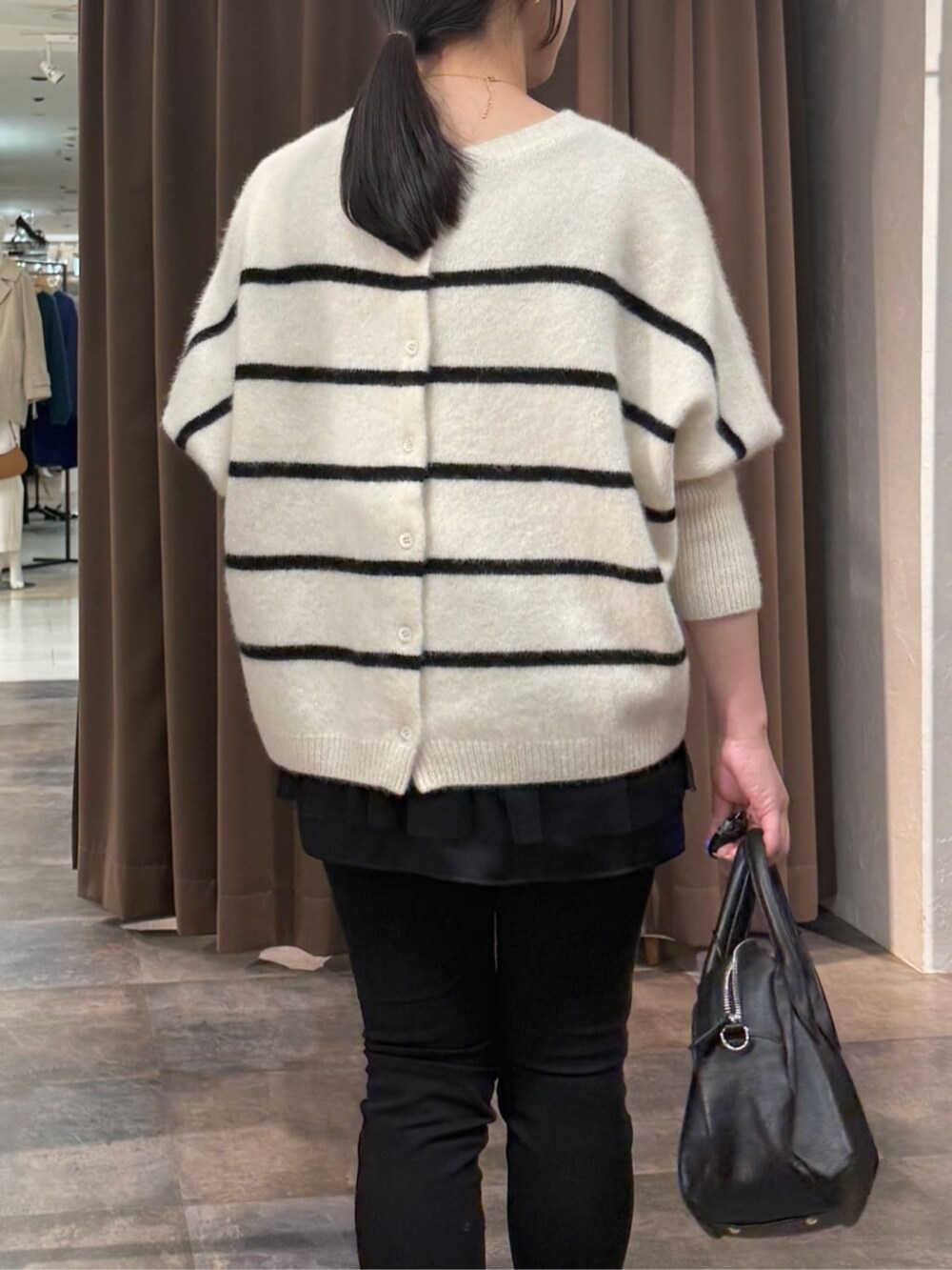 ブラック系のその他パンツ、ホワイト系のニット/セーター、ブラック系のタンクトップを着用したレディースの冬コーディネートの6枚目の写真