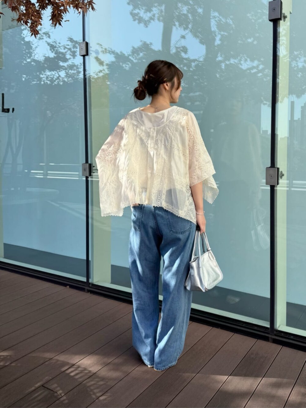 ブルー系のデニムパンツ、シルバー系のトートバッグ、ベージュ系のシャツ/ブラウスを着用したレディースの冬コーディネートの3枚目の写真