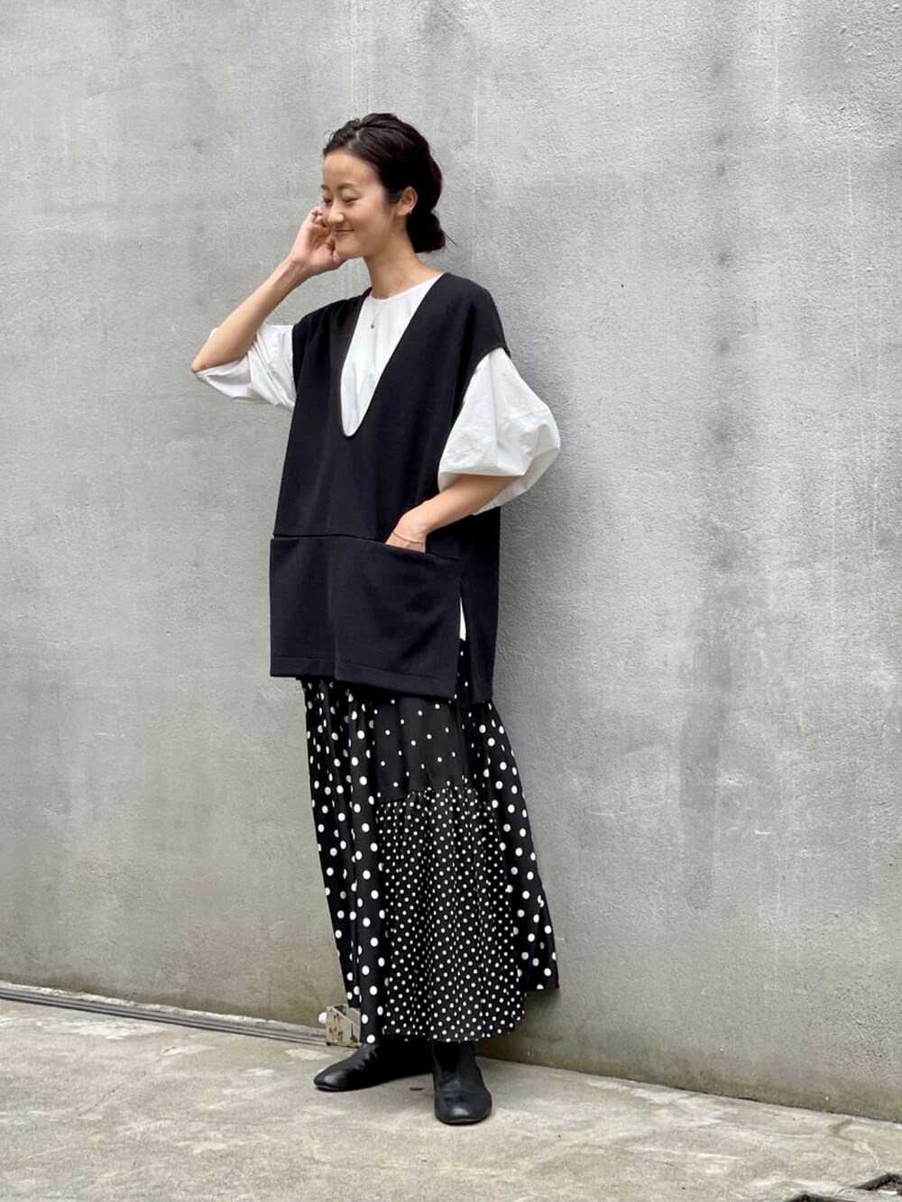 ブラック系のスカート、ホワイト系のシャツ/ブラウス、ブラック系のブーツを着用したレディースの夏コーディネートの5枚目の写真