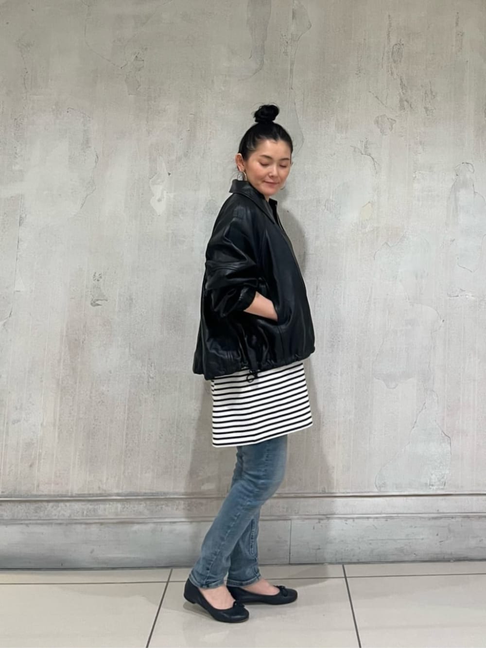 ブルー系のデニムパンツ、ブラック系のブルゾンを着用したレディースの冬コーディネートの5枚目の写真