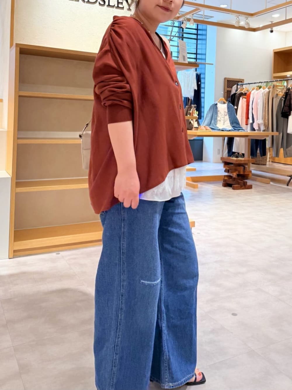 ベージュ系のショルダーバッグ、ブルー系のその他パンツ、レッド系のシャツ/ブラウスを着用したレディースの春コーディネートの5枚目の写真
