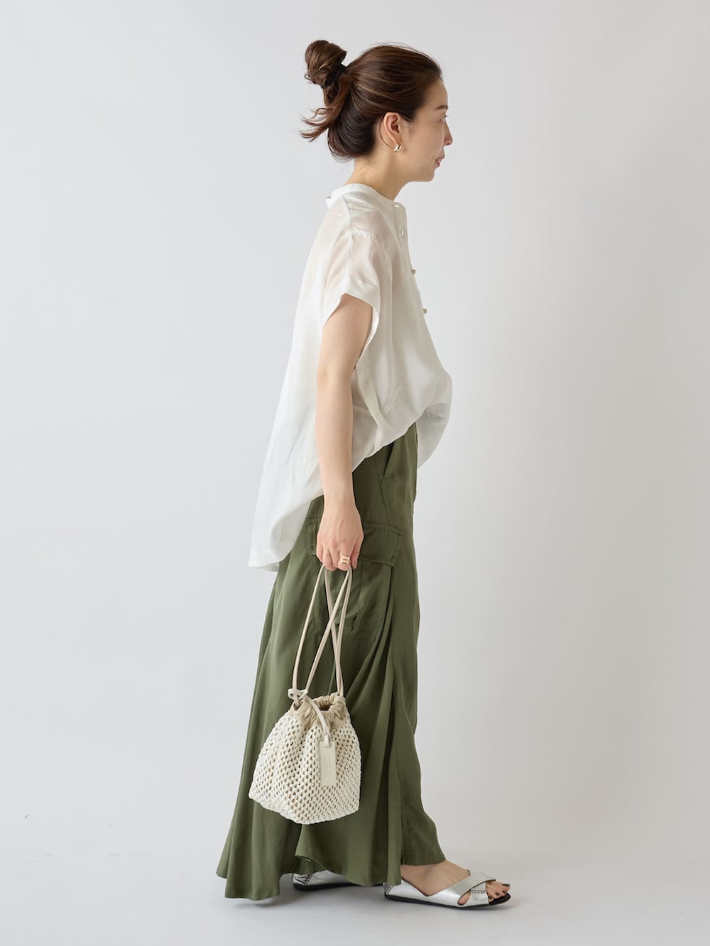 ベージュ系のノーカラージャケット、ホワイト系のシャツ/ブラウス、グリーン系のスカートを着用したレディースの夏コーディネートの4枚目の写真