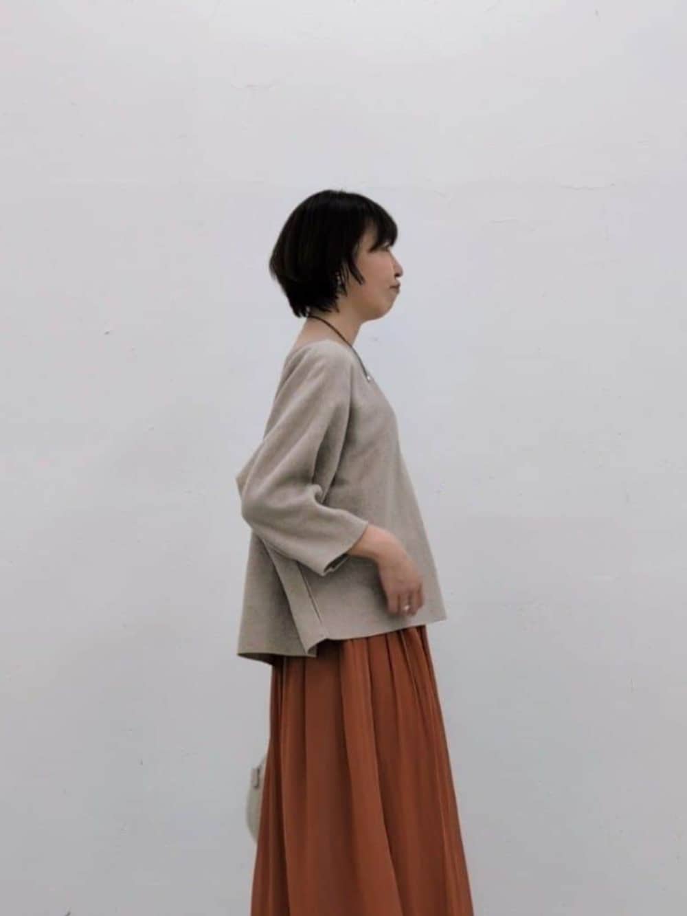 グレー系のボストンバッグ、オレンジ系のその他パンツ、ベージュ系のニット/セーターを着用したレディースの冬コーディネートの5枚目の写真