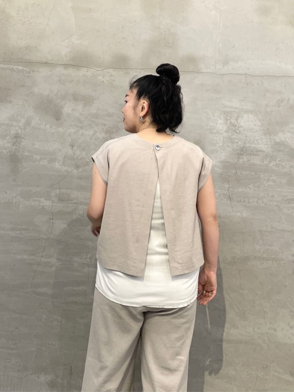 ホワイト系のタンクトップ、ブラック系のショルダーバッグ、ブラック系のサンダルを着用したレディースの春コーディネートの6枚目の写真