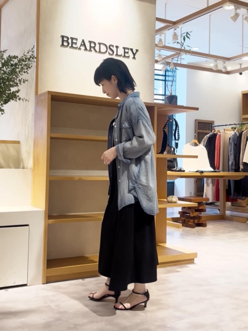 ブルー系のシャツ/ブラウス、ブラック系のワンピースを着用したレディースの春コーディネートの2枚目の写真