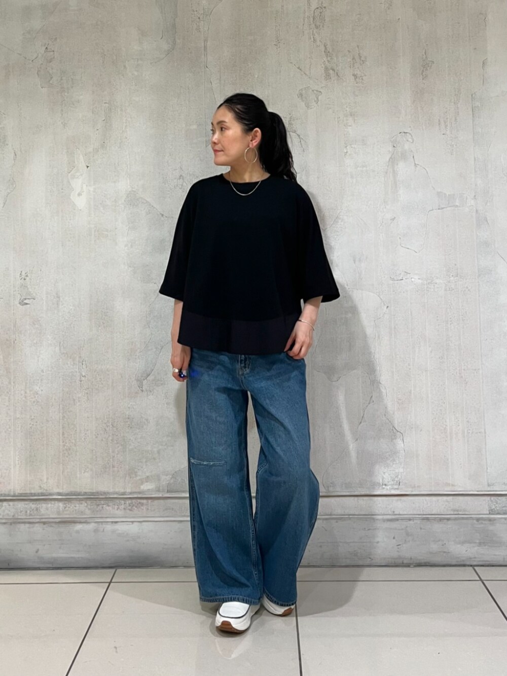 ブルー系のその他パンツ、ブラック系のTシャツ/カットソー、ホワイト系のスニーカーを着用したレディースの春コーディネートの6枚目の写真