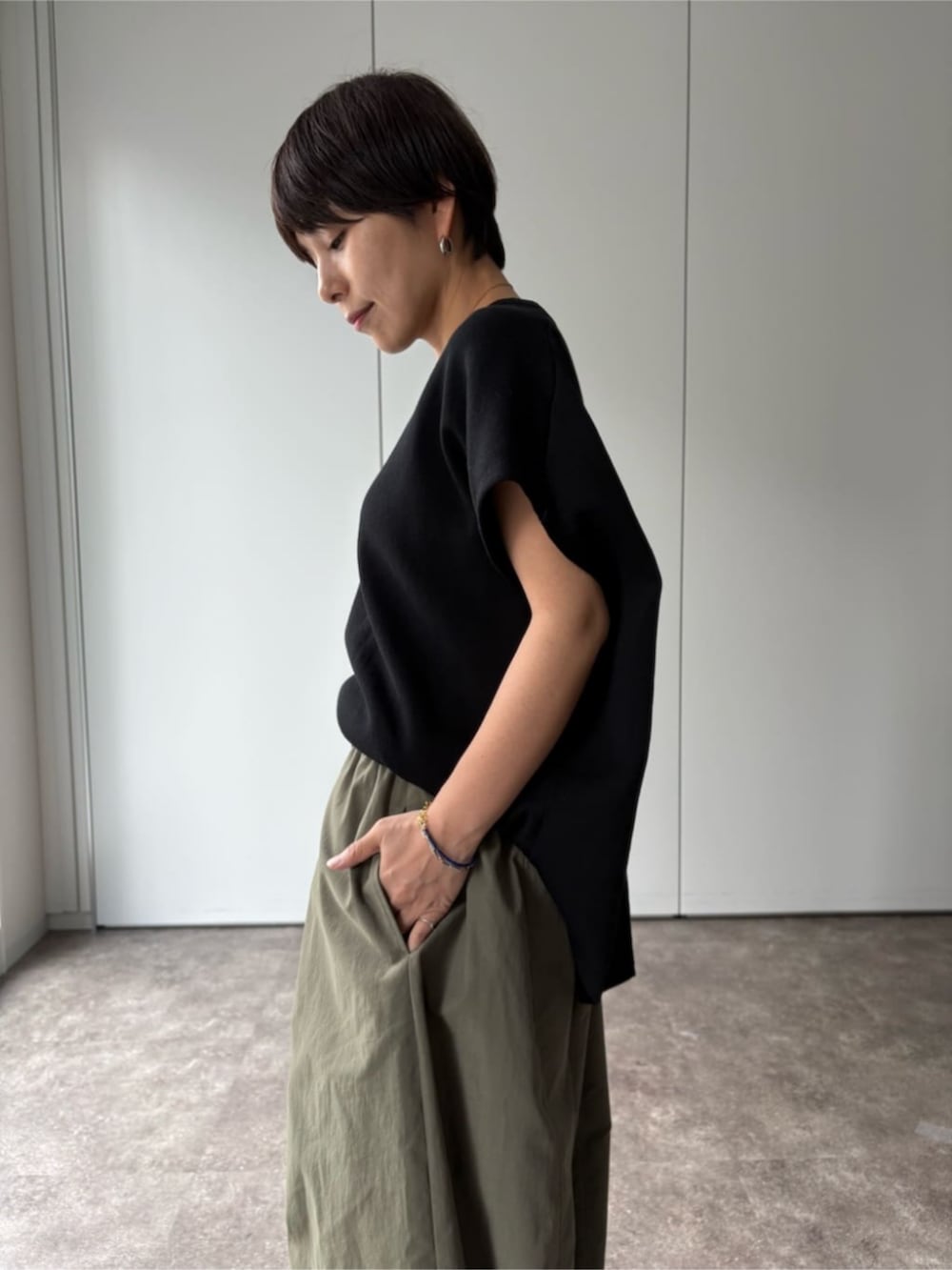ブラック系のニット/セーター、グリーン系のその他パンツを着用したレディースの夏コーディネートの4枚目の写真