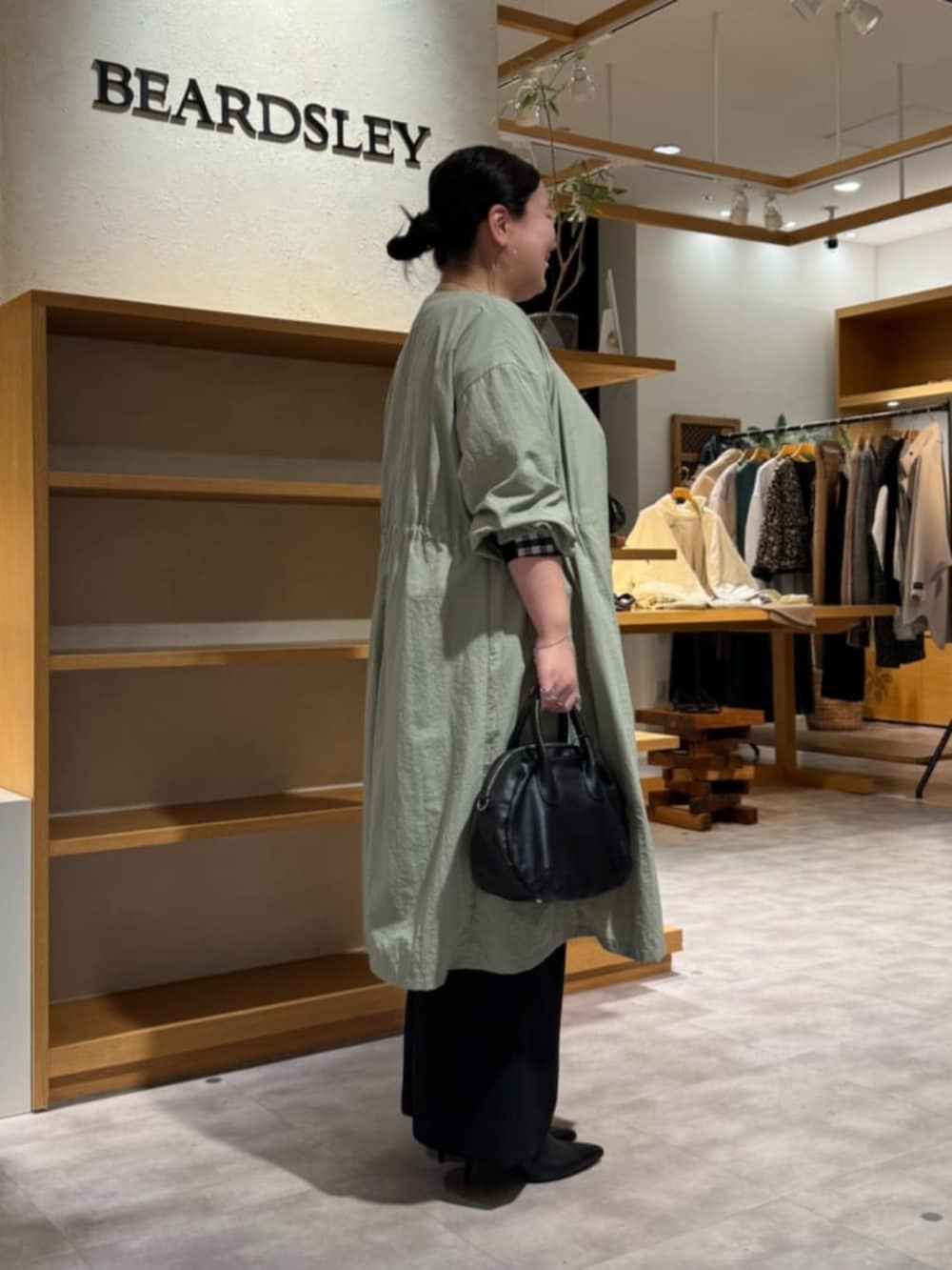 ブラック系のその他パンツ、ブラック系のシャツ/ブラウス、グリーン系のその他アウターを着用したレディースの冬コーディネートの2枚目の写真