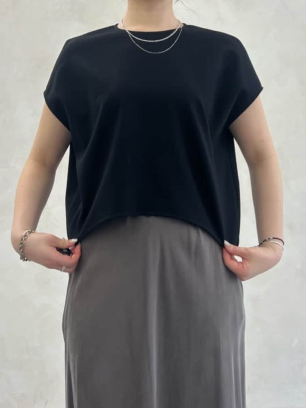 グリーン系のスカート、ブラック系のシャツ/ブラウスを着用したレディースの春コーディネートの4枚目の写真