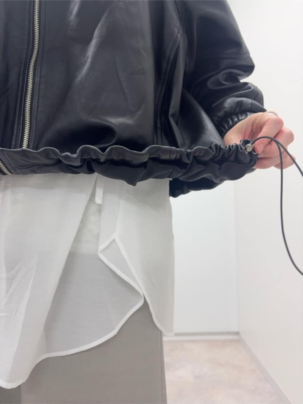 ブラック系のブルゾン、ホワイト系のシャツ/ブラウスを着用したレディースの冬コーディネートの8枚目の写真