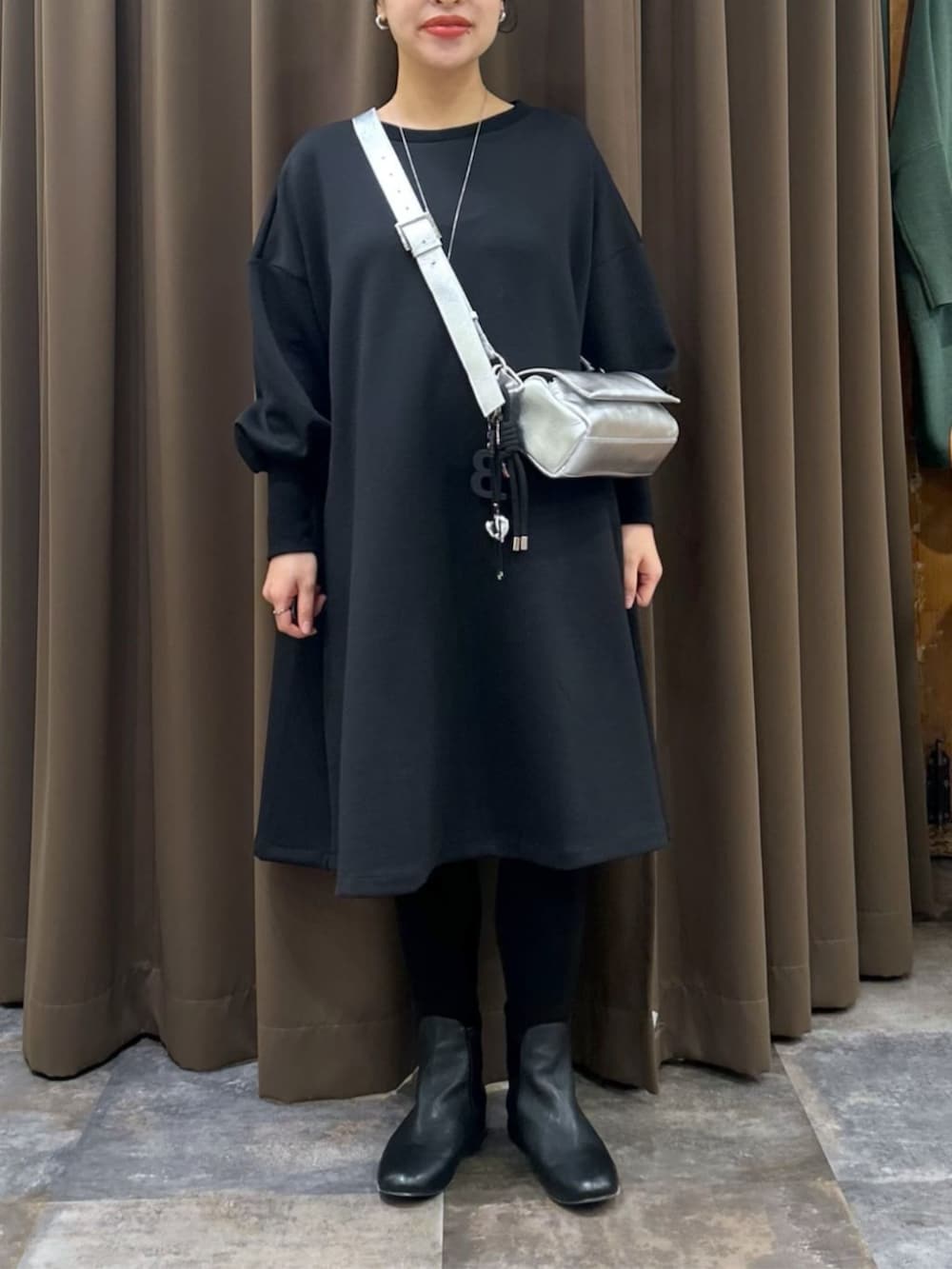 ブラック系のワンピース、ブラック系のチャームを着用したレディースの冬コーディネートの2枚目の写真