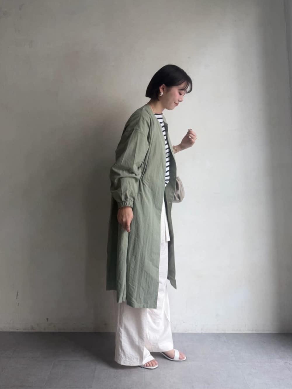 グリーン系のその他アウター、ホワイト系のその他パンツ、ホワイト系のTシャツ/カットソーを着用したレディースの冬コーディネートの3枚目の写真