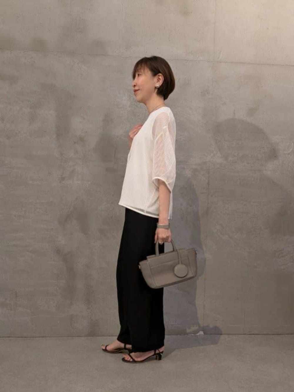 ブラック系のその他パンツ、ホワイト系のシャツ/ブラウスを着用したレディースの春コーディネートの2枚目の写真