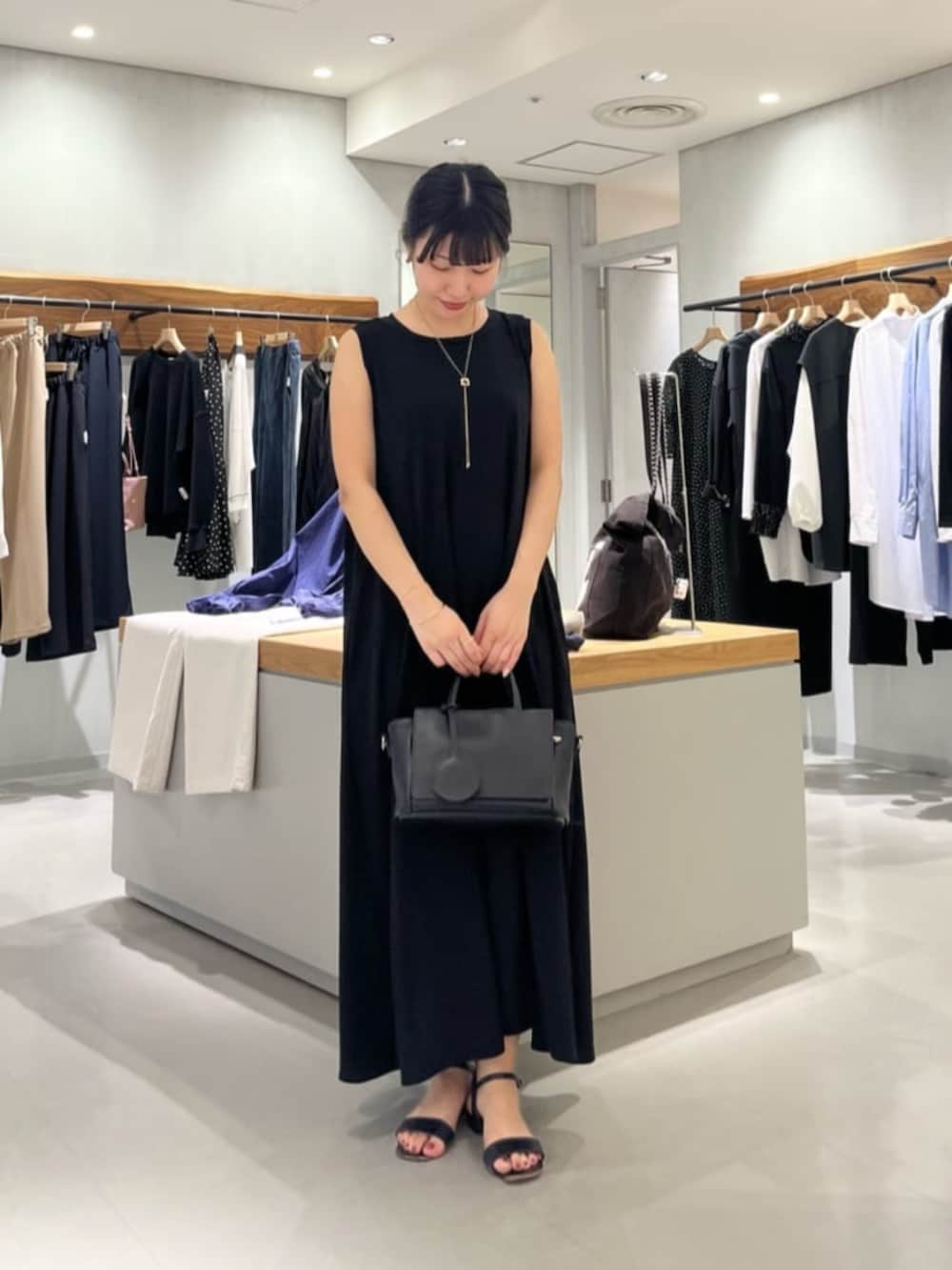 ブラック系のハンドバッグ、ブラック系のワンピースを着用したレディースの春コーディネートの5枚目の写真