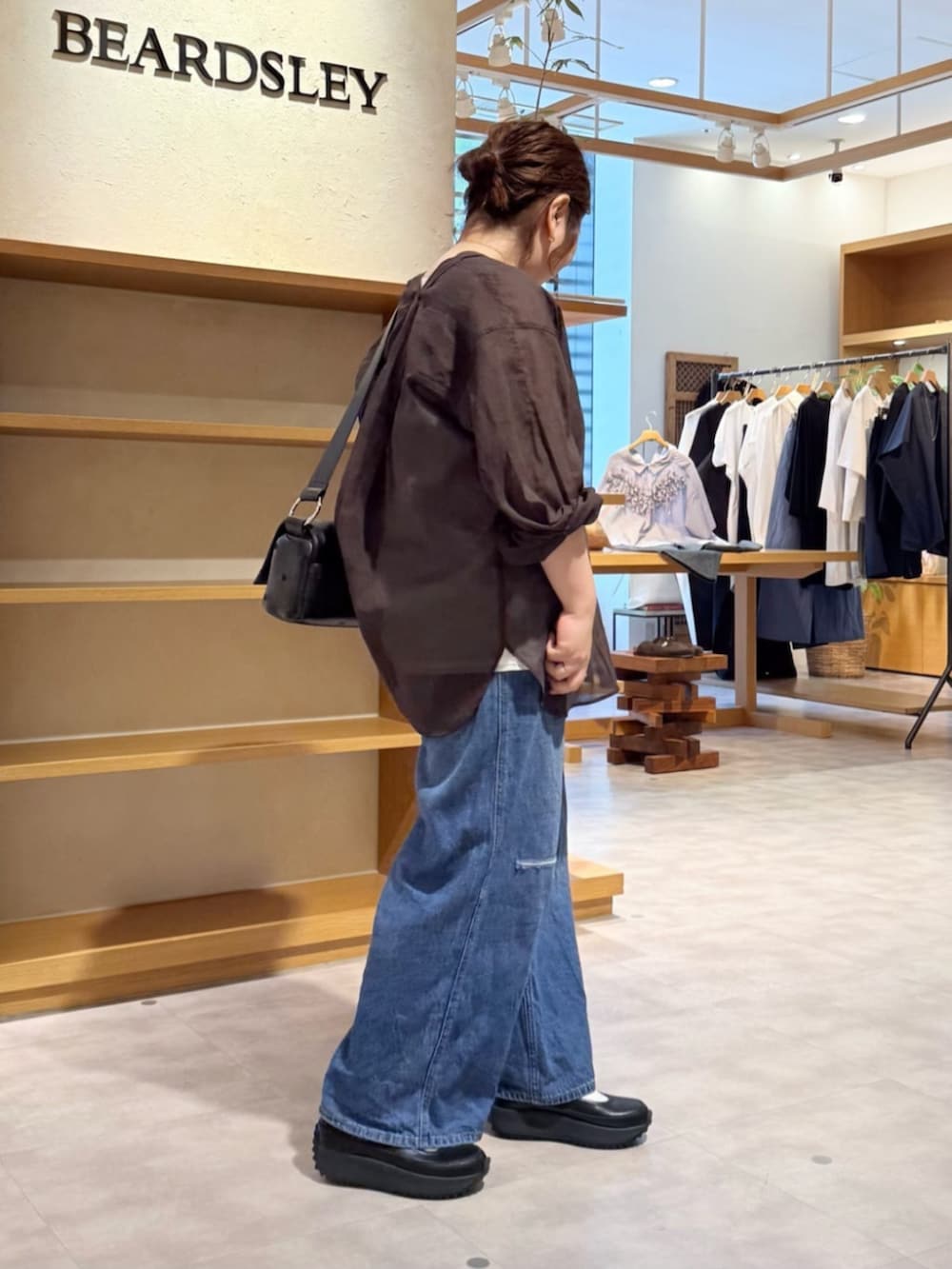 ブルー系のその他パンツ、ブラック系のスニーカー、ブラウン系のシャツ/ブラウスを着用したレディースの春コーディネートの4枚目の写真