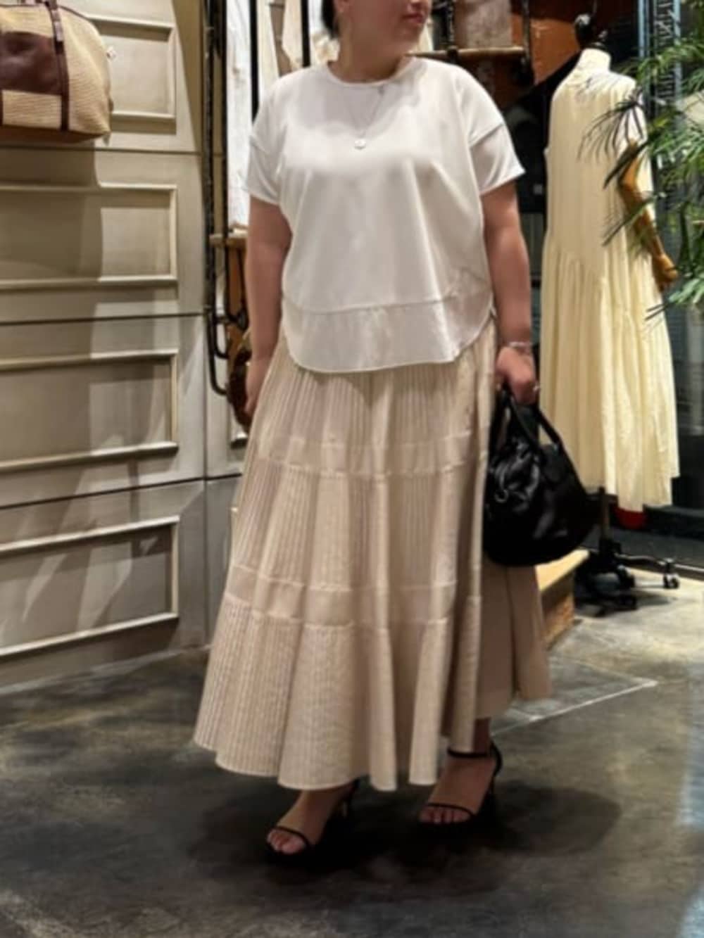 ホワイト系のスカート、ブラック系のテーラードジャケットを着用したレディースの春コーディネートの7枚目の写真