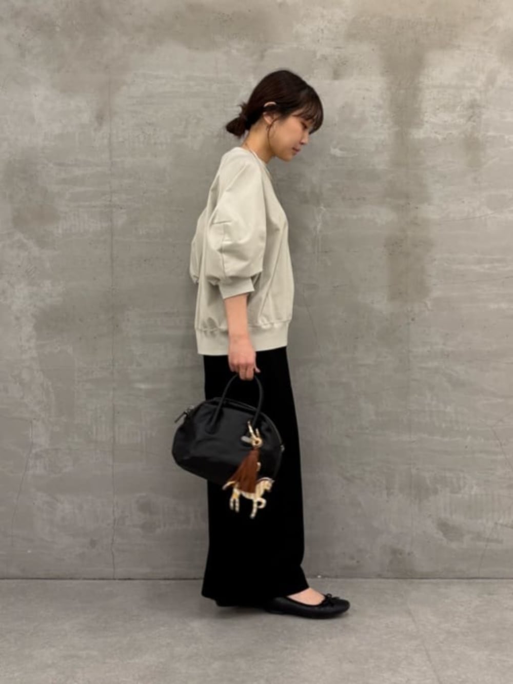 ブラック系のボストンバッグ、ブラック系のその他パンツ、グレー系のTシャツ/カットソーを着用したレディースの冬コーディネートの4枚目の写真