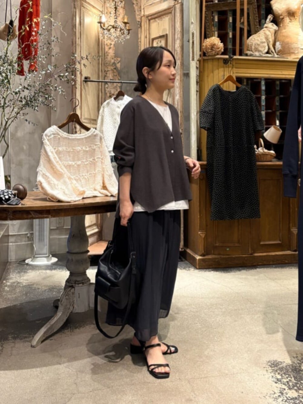 ブラック系のその他パンツ、ホワイト系のシャツ/ブラウス、グレー系のカーディガン/ボレロを着用したレディースの春コーディネートの10枚目の写真