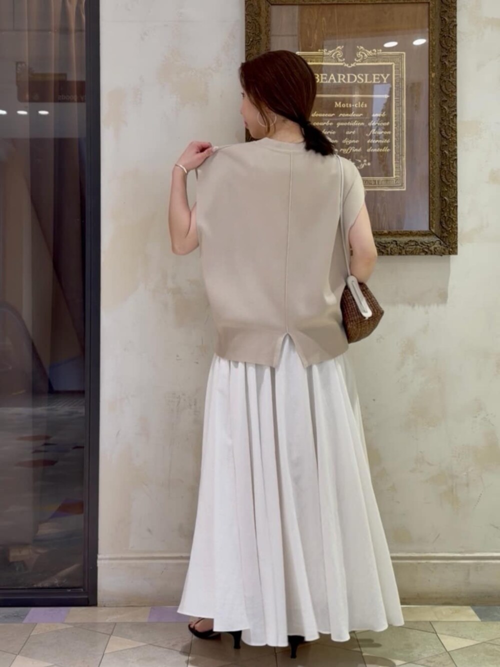 ホワイト系のスカート、ベージュ系のカーディガン/ボレロを着用したレディースの春コーディネートの5枚目の写真