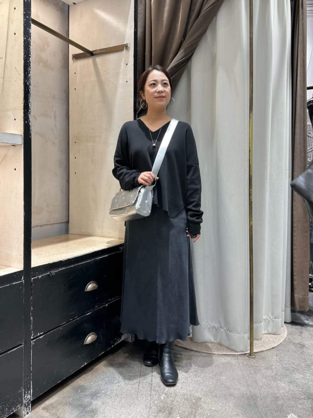 ブラック系のスカート、ブルー系のピーコート、シルバー系のショルダーバッグを着用したレディースの冬コーディネートの2枚目の写真