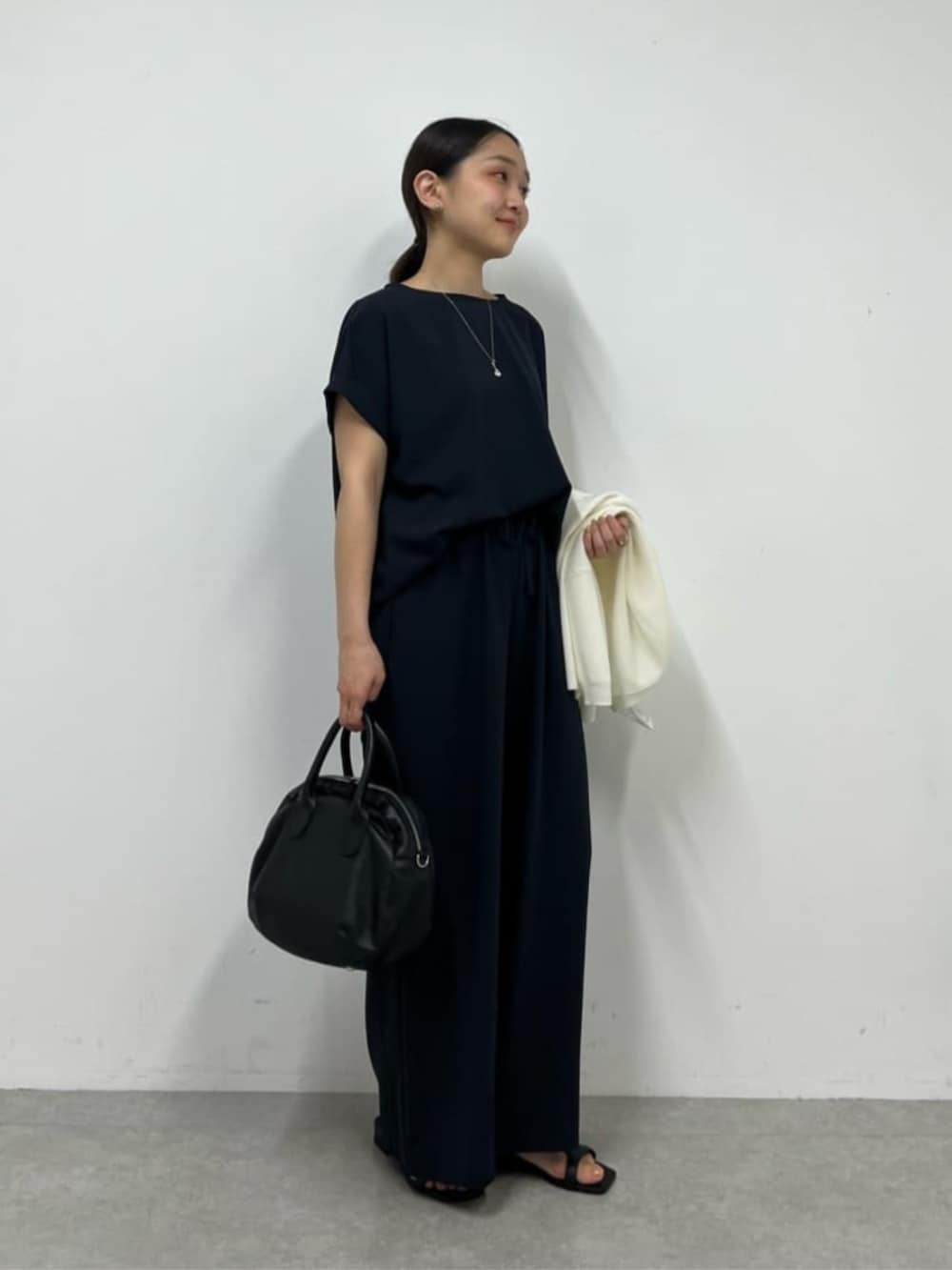 ブラック系のボストンバッグ、ブルー系のシャツ/ブラウス、ブルー系のその他パンツを着用したレディースの春コーディネートの3枚目の写真