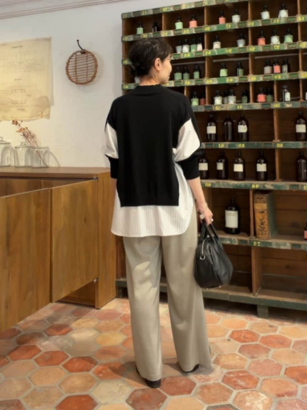 グレー系のその他パンツ、ブラック系のニット/セーターを着用したレディースの秋コーディネートの3枚目の写真