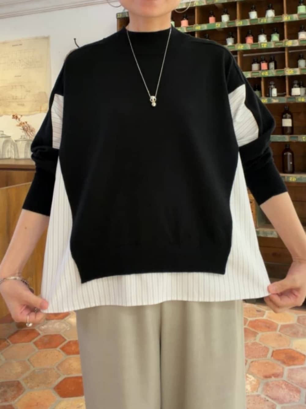グレー系のその他パンツ、ブラック系のニット/セーターを着用したレディースの秋コーディネートの7枚目の写真