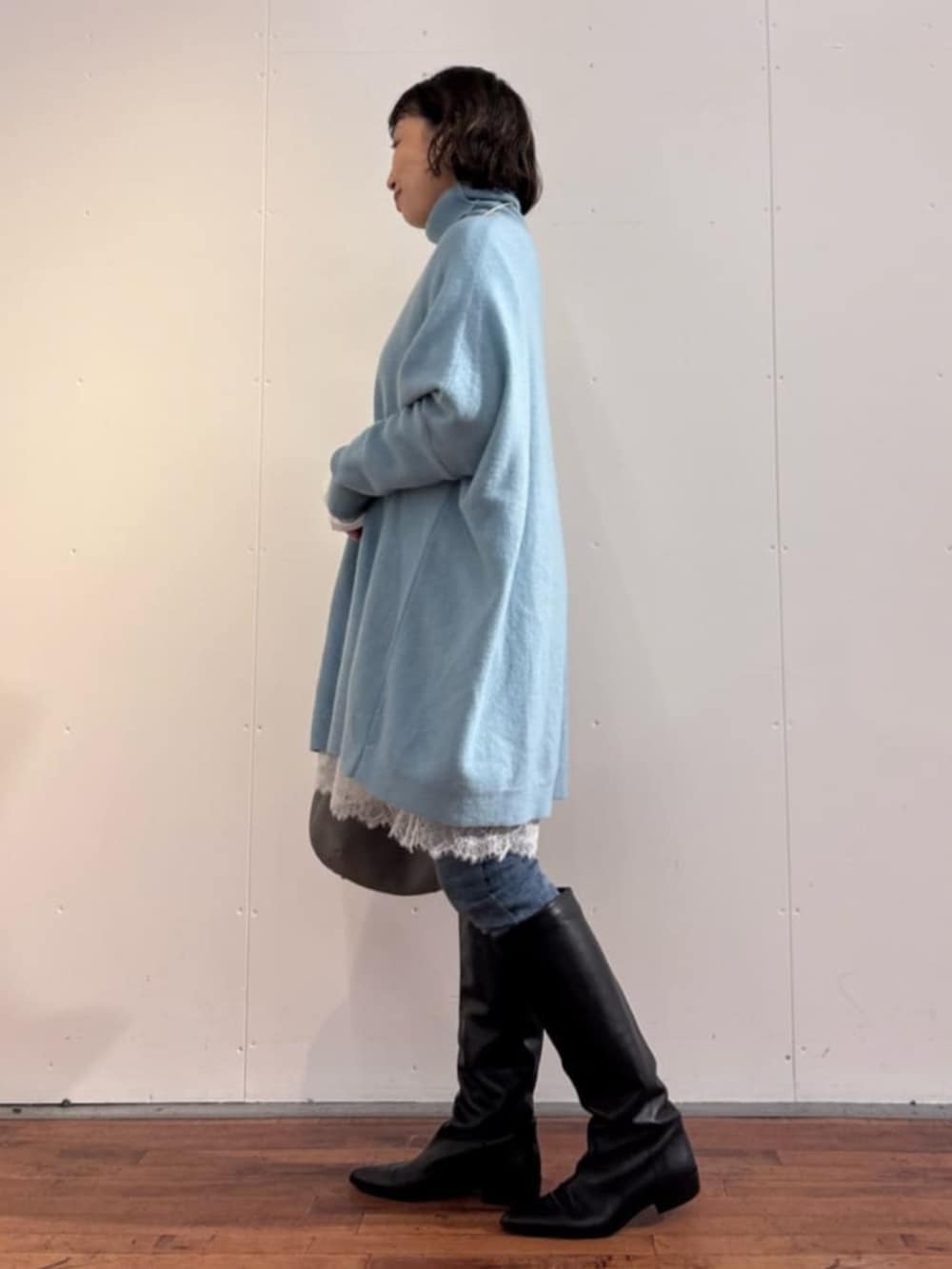 ブルー系のデニムパンツ、グレー系のトートバッグ、ホワイト系のTシャツ/カットソーを着用したレディースの秋コーディネートの3枚目の写真