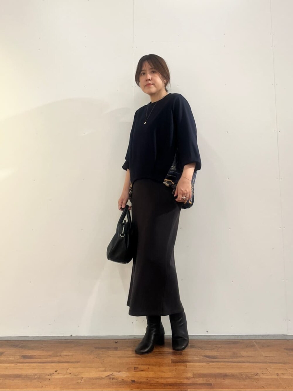 グレー系のスカート、ブラック系のトートバッグ、ブルー系のTシャツ/カットソーを着用したレディースの夏コーディネートの4枚目の写真