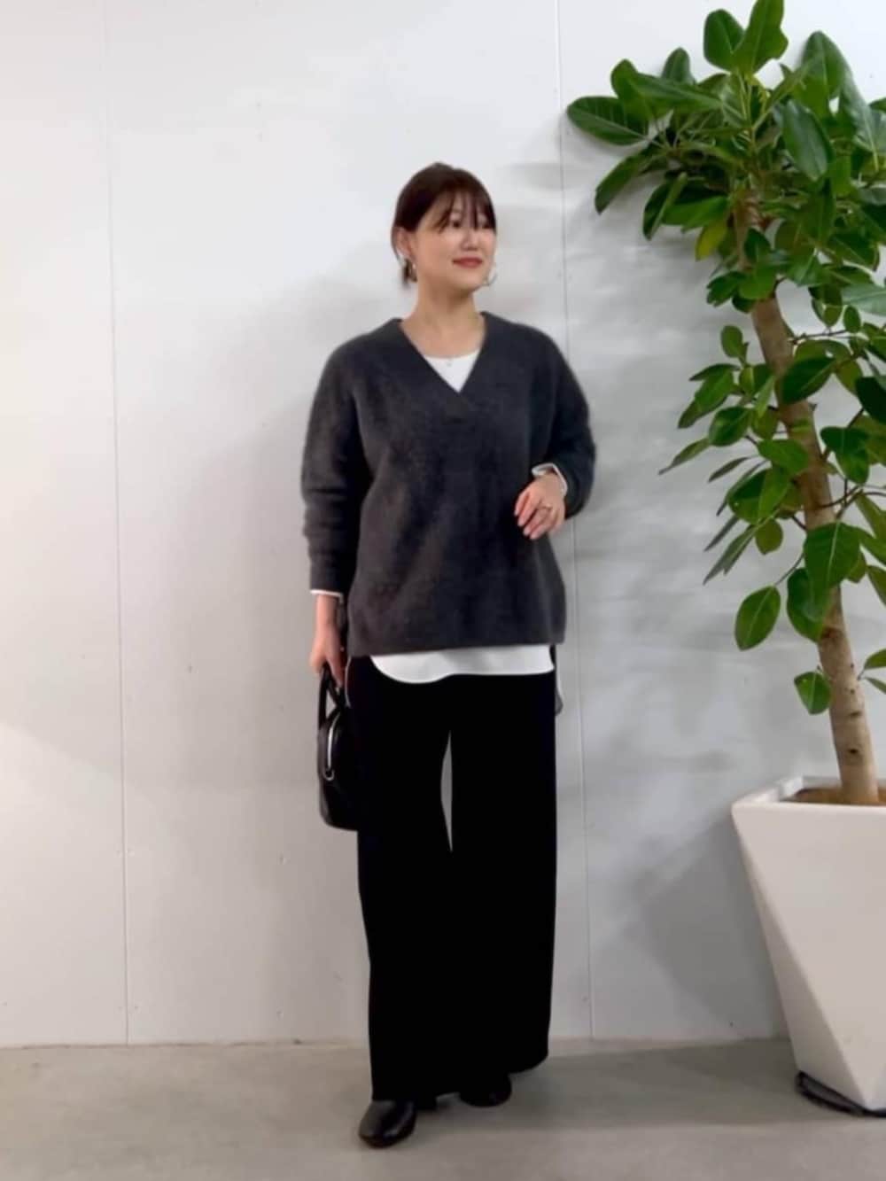 ブラック系のトートバッグ、グレー系のニット/セーター、ホワイト系のシャツ/ブラウスを着用したレディースの秋コーディネートの4枚目の写真