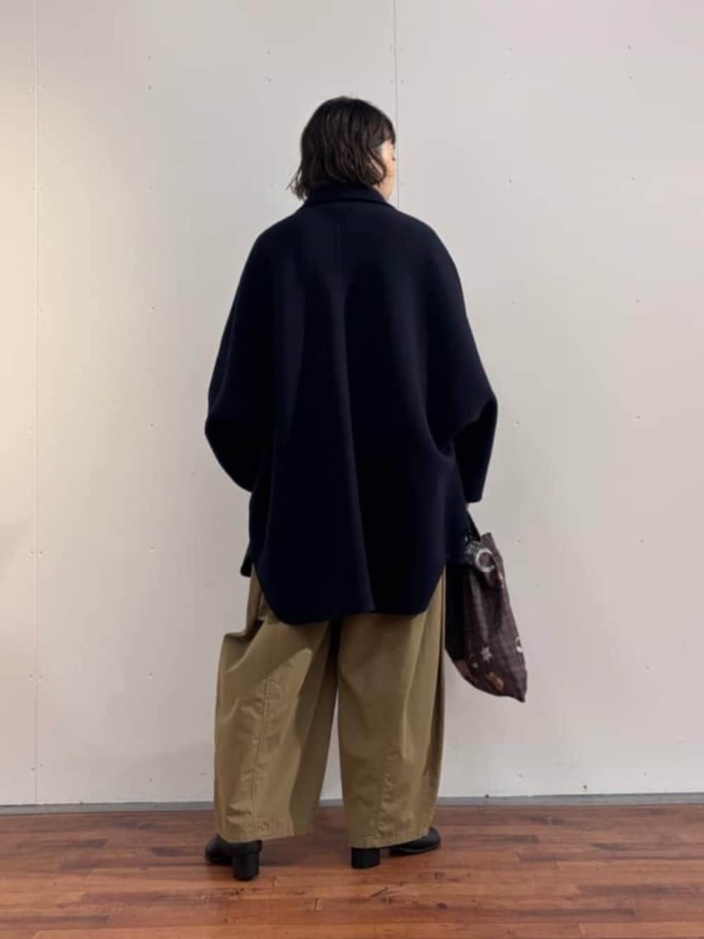 イエロー系のその他パンツ、ブラック系のニット/セーター、ブラック系のブーツを着用したレディースの秋コーディネートの8枚目の写真