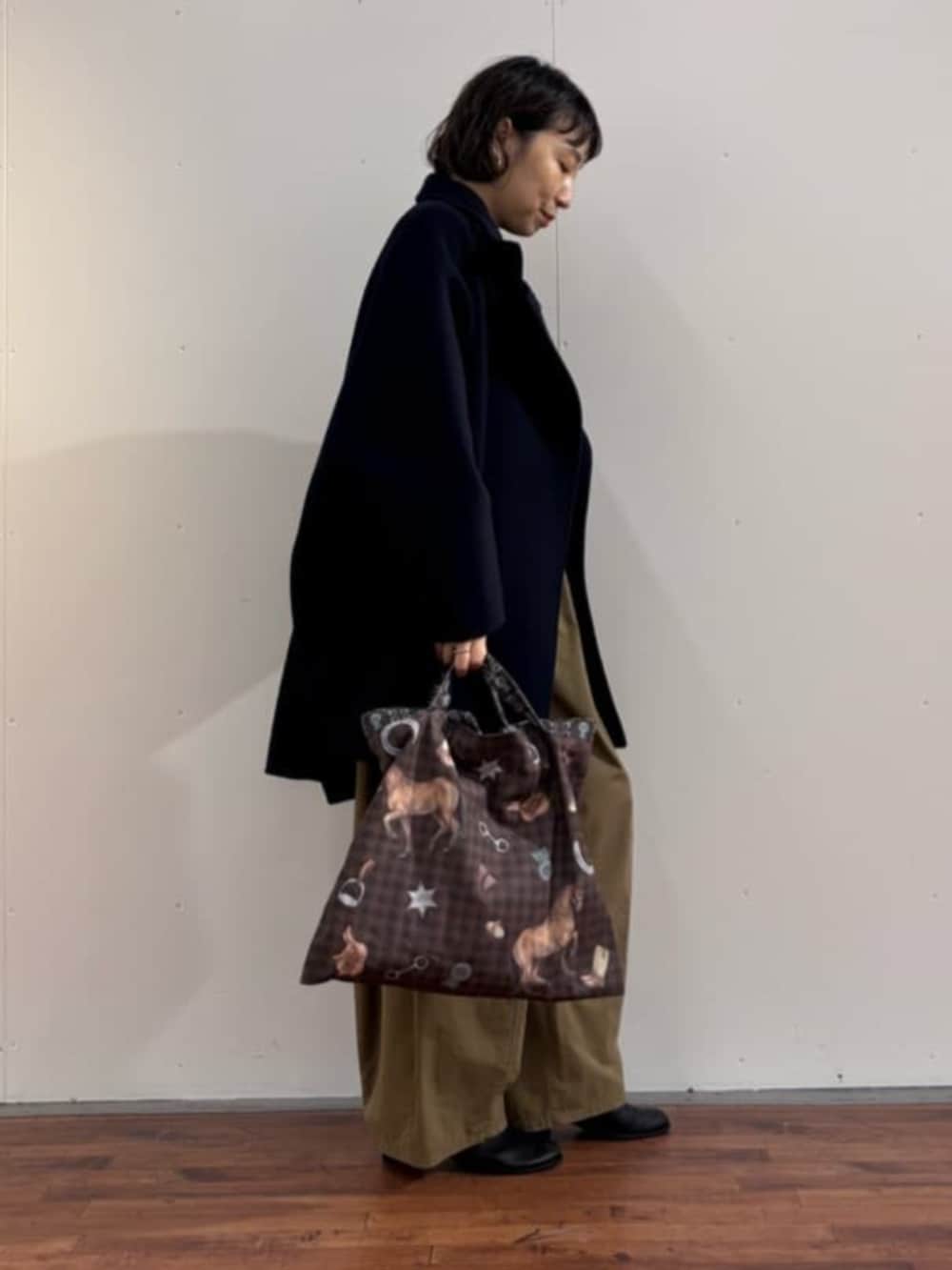 イエロー系のその他パンツ、ブラック系のニット/セーター、ブラック系のブーツを着用したレディースの秋コーディネートの3枚目の写真