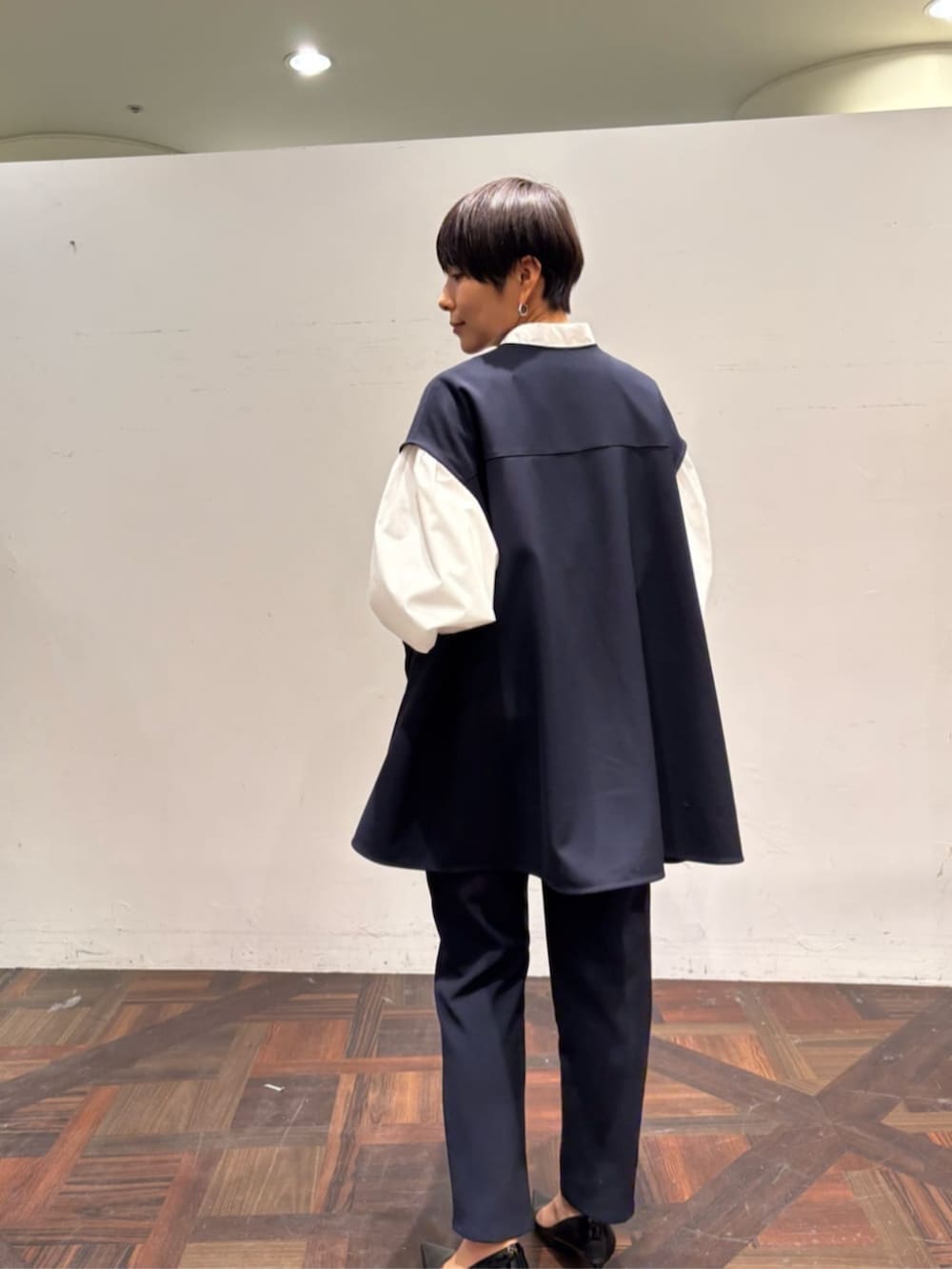 ブラック系のボストンバッグ、ブルー系のベスト、ホワイト系のシャツ/ブラウスを着用したレディースの冬コーディネートの4枚目の写真