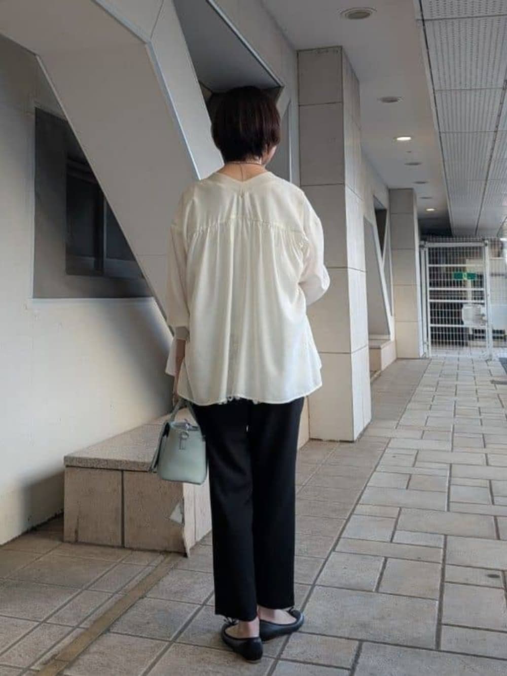 ホワイト系のシャツ/ブラウス、ホワイト系のTシャツ/カットソー、ブラック系のその他パンツを着用したレディースの冬コーディネートの4枚目の写真