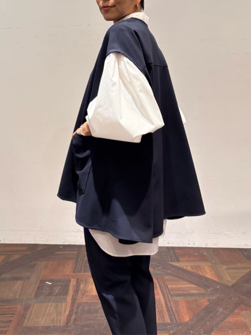 ブラック系のボストンバッグ、ブルー系のベスト、ホワイト系のシャツ/ブラウスを着用したレディースの冬コーディネートの8枚目の写真