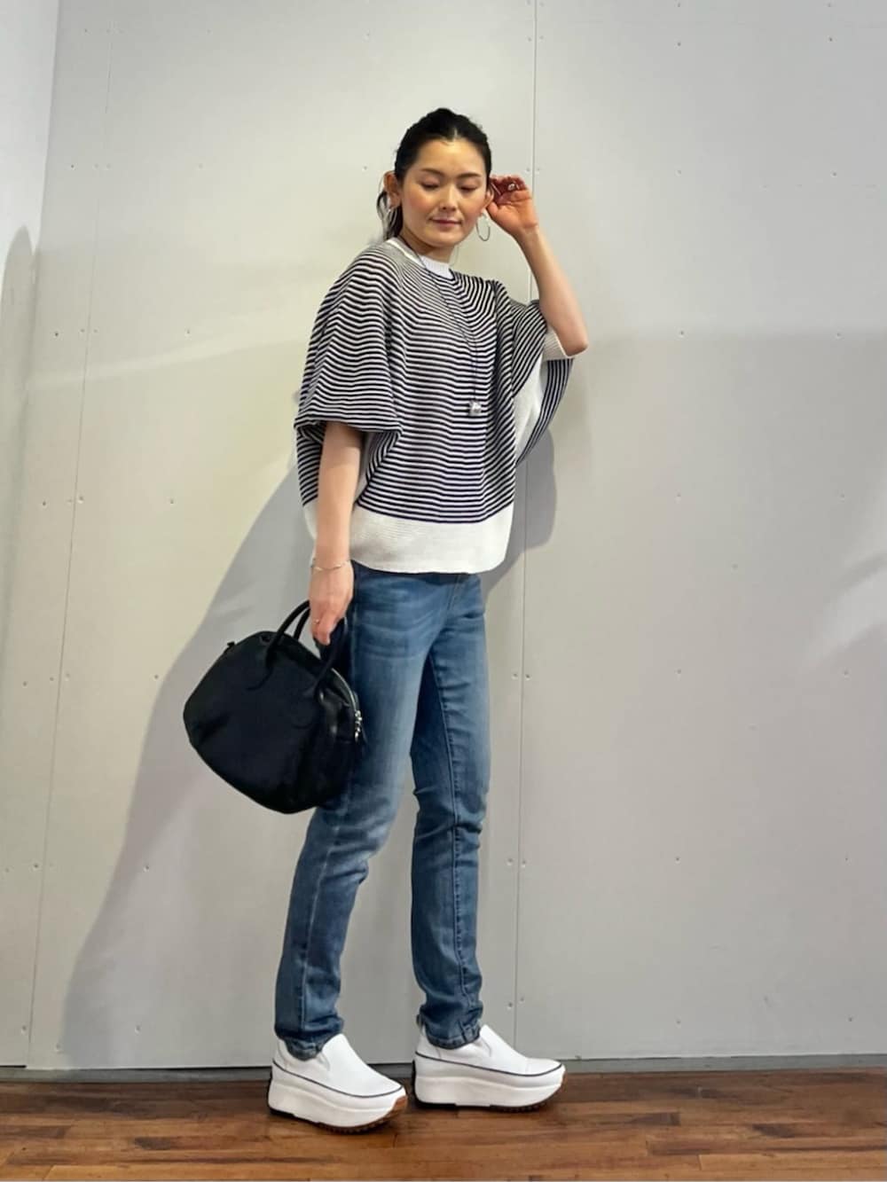 ブルー系のデニムパンツ、ブルー系のニット/セーターを着用したレディースの春コーディネートの2枚目の写真