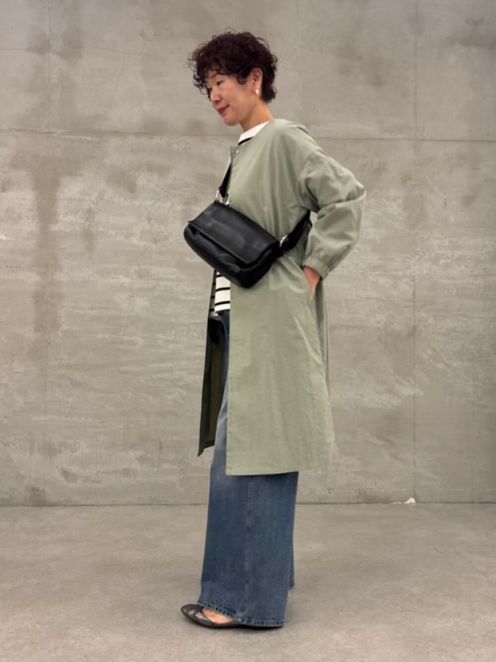 ブラック系のショルダーバッグ、グリーン系のその他アウター、ホワイト系のニット/セーターを着用したレディースの冬コーディネートの4枚目の写真