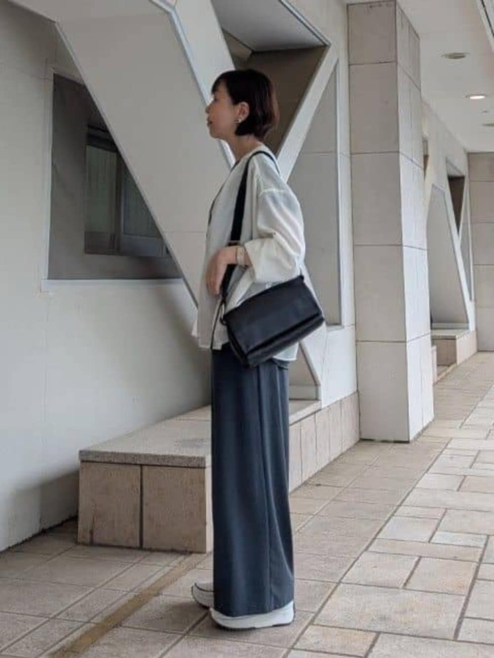 グレー系のその他パンツ、ホワイト系のシャツ/ブラウス、ホワイト系のスニーカーを着用したレディースの春コーディネートの2枚目の写真