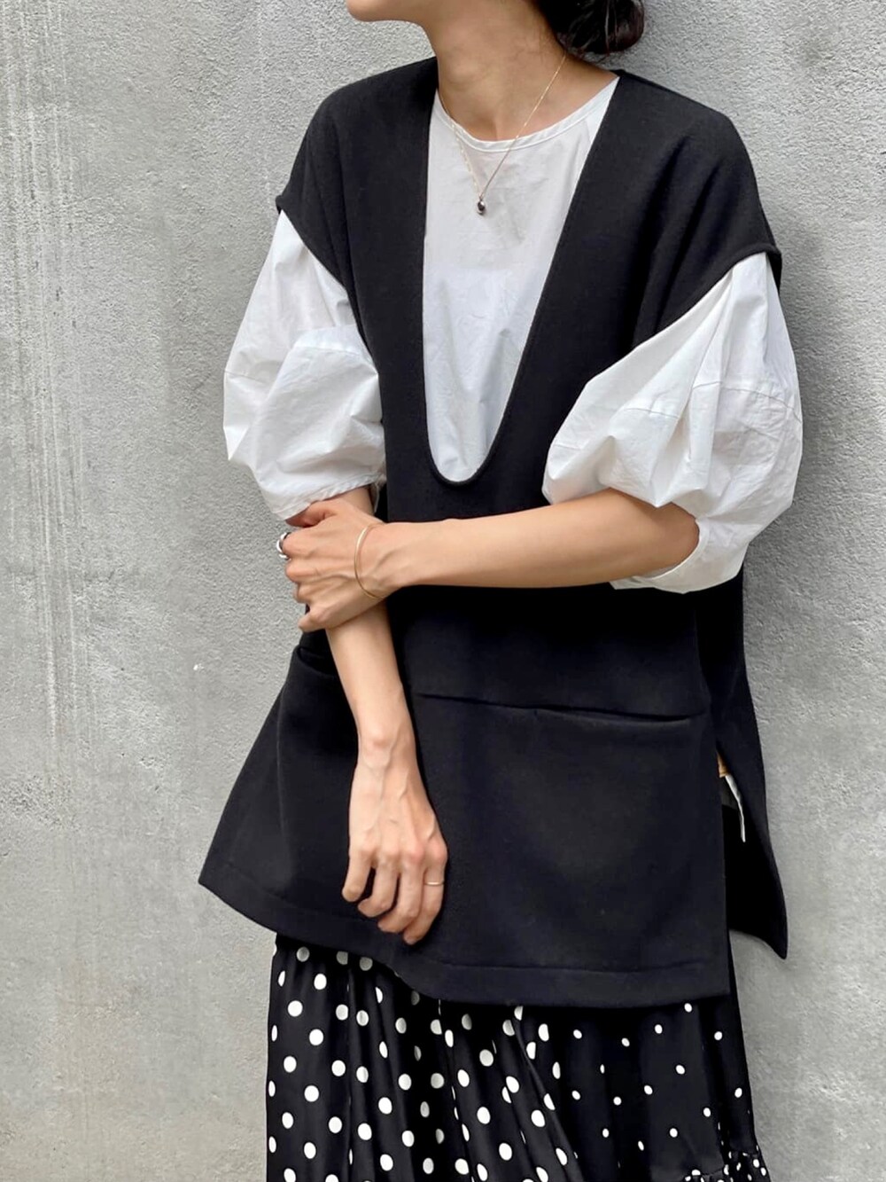 ブラック系のスカート、ホワイト系のシャツ/ブラウス、ブラック系のブーツを着用したレディースの夏コーディネートの3枚目の写真