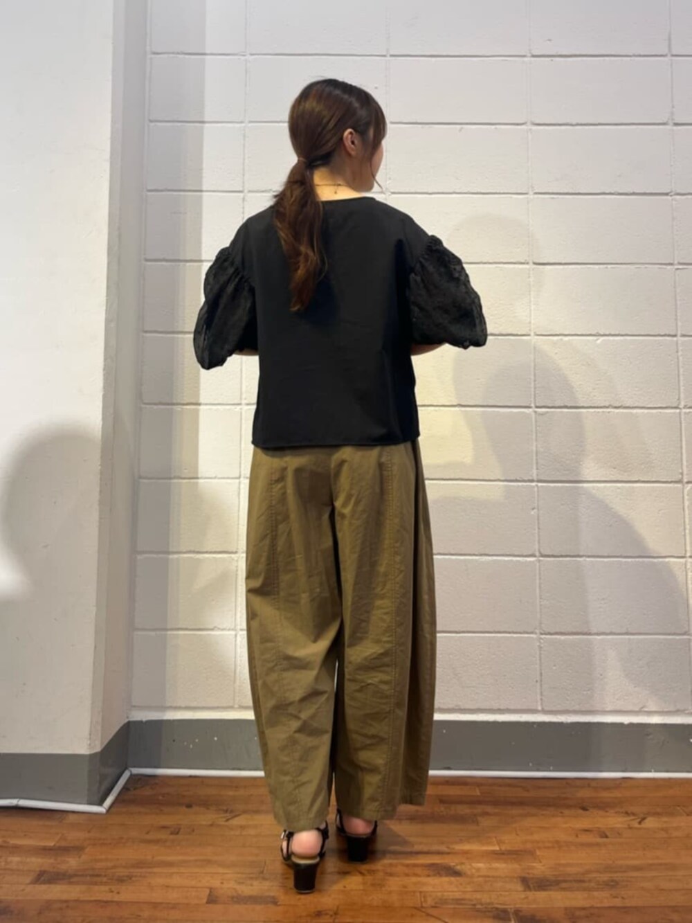 イエロー系のその他パンツ、ブラック系のシャツ/ブラウスを着用したレディースの夏コーディネートの3枚目の写真